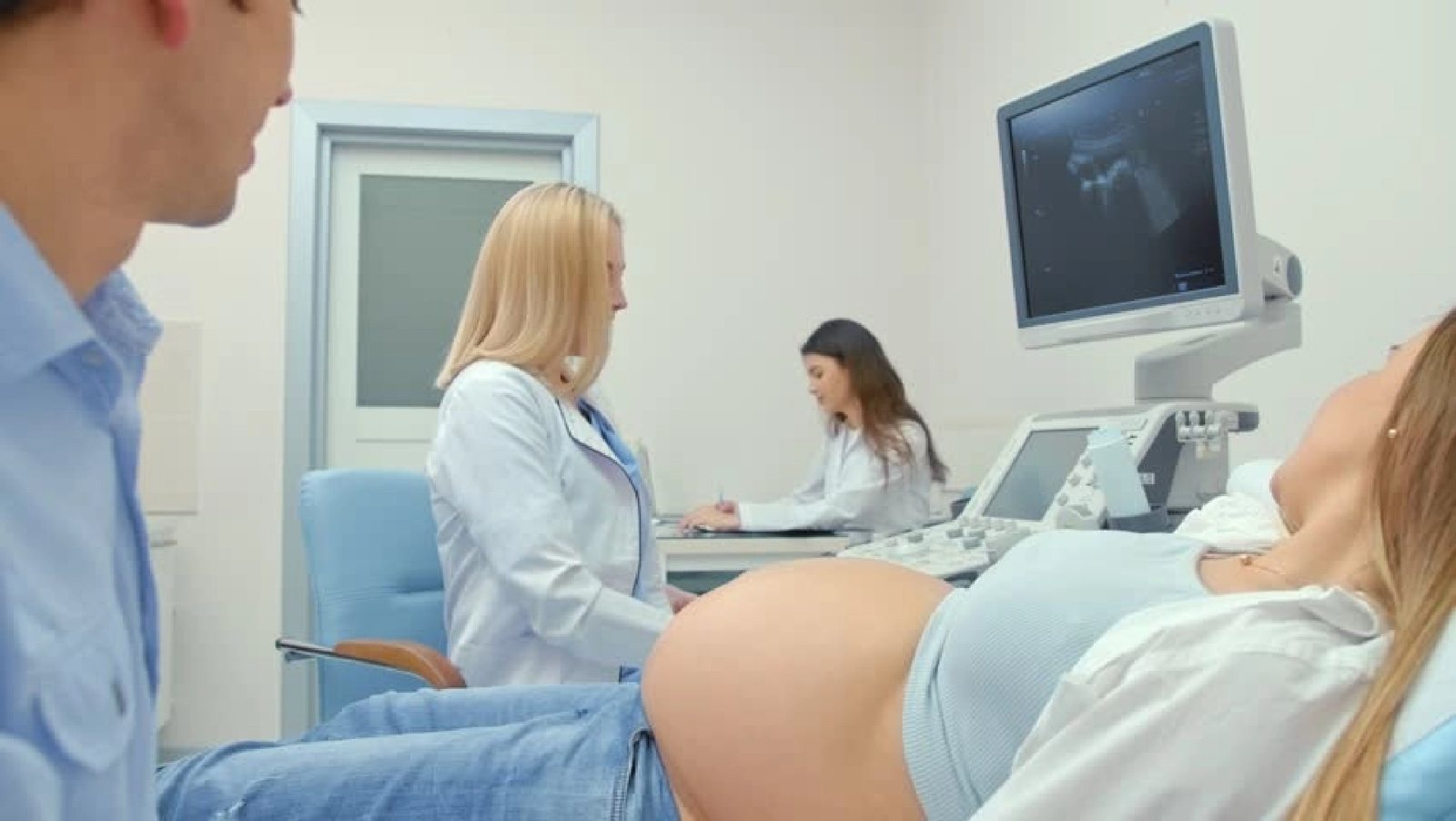 Pregnant woman having an obstetric ultrasound performed by a sonographer
